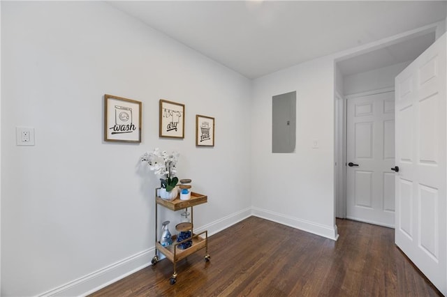 hall featuring electric panel, wood finished floors, and baseboards