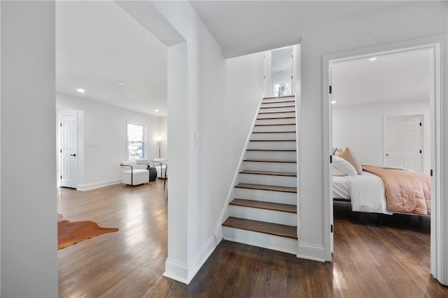 stairs with wood finished floors, baseboards, and recessed lighting