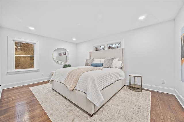 bedroom featuring baseboards, wood finished floors, and recessed lighting