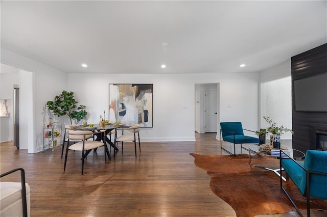dining room featuring recessed lighting, wood finished floors, baseboards, and a fireplace