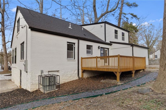 back of property featuring a deck, a shingled roof, and brick siding