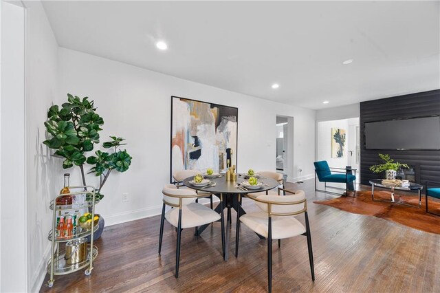dining area featuring baseboards, wood finished floors, and recessed lighting