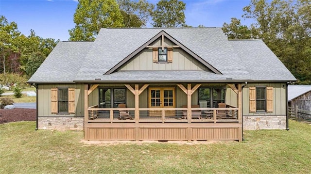 rear view of property featuring a wooden deck and a lawn