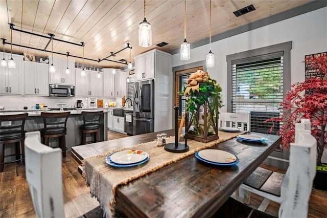 dining space with wood ceiling, dark wood-type flooring, and rail lighting