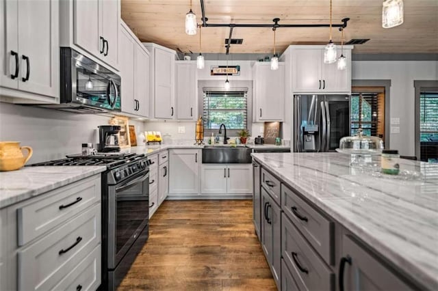 kitchen with sink, appliances with stainless steel finishes, white cabinets, and plenty of natural light