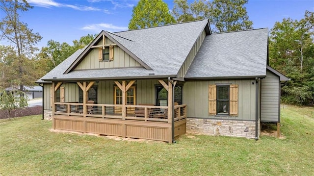 rear view of house with covered porch and a lawn