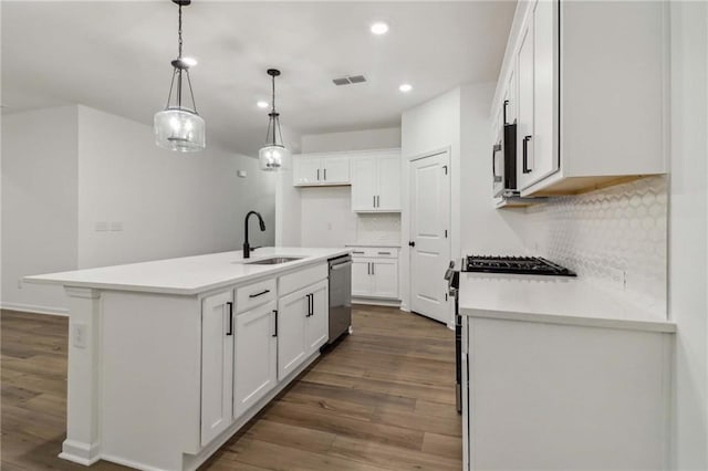 kitchen featuring stainless steel appliances, wood finished floors, a sink, visible vents, and white cabinets