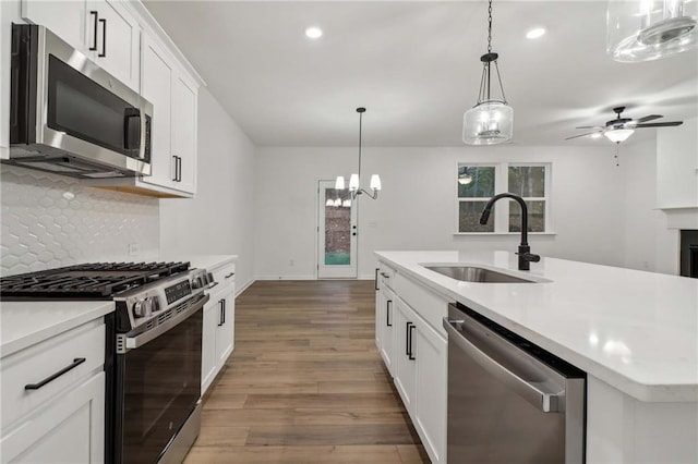 kitchen featuring wood finished floors, stainless steel appliances, a sink, and light countertops