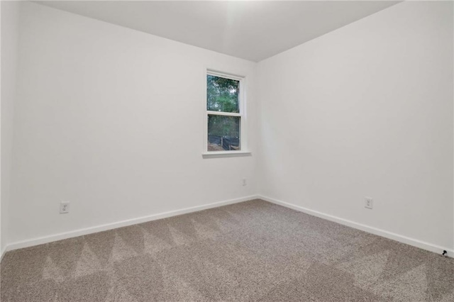 unfurnished room featuring carpet floors and baseboards