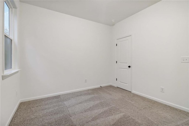 carpeted spare room with baseboards