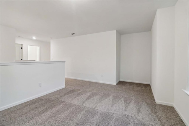 empty room featuring carpet, baseboards, and recessed lighting