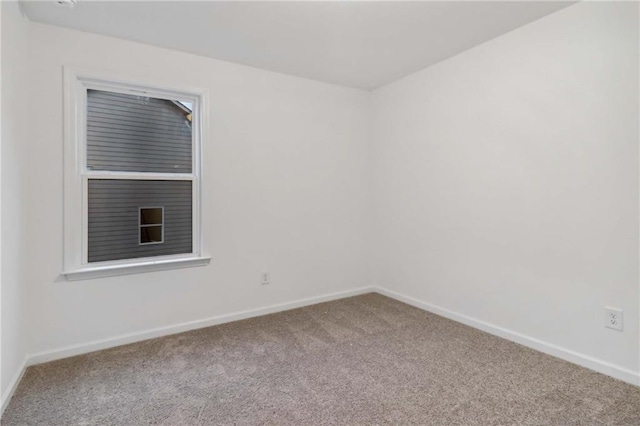 unfurnished room with carpet flooring and baseboards