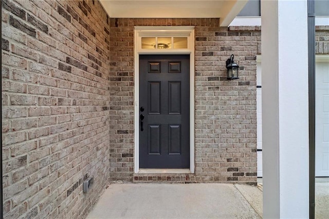 doorway to property with brick siding