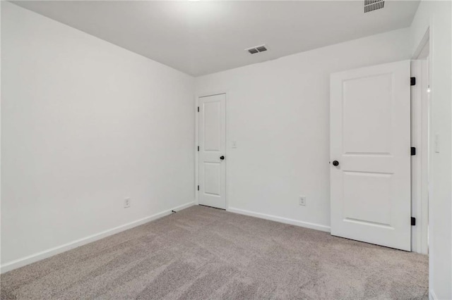 spare room featuring baseboards, visible vents, and carpet flooring