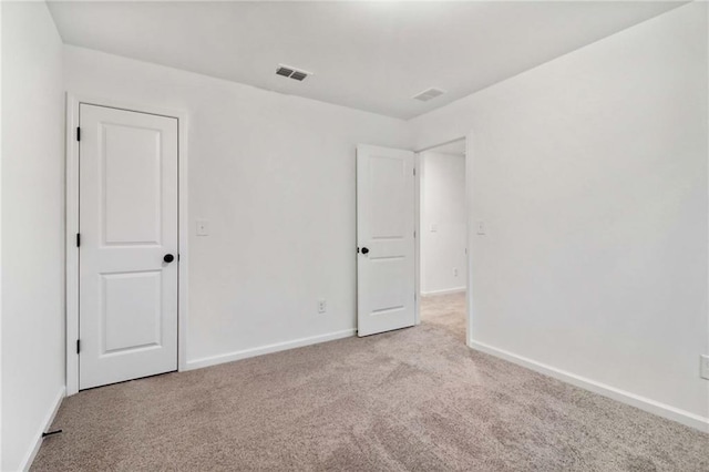 unfurnished bedroom with baseboards, visible vents, and carpet flooring