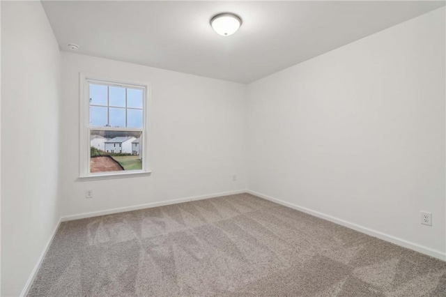 spare room featuring carpet floors and baseboards