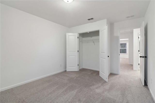 unfurnished bedroom with carpet, visible vents, baseboards, and a closet