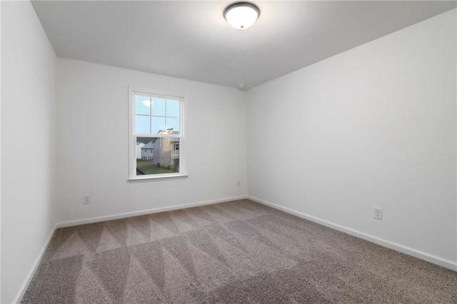 carpeted empty room featuring baseboards