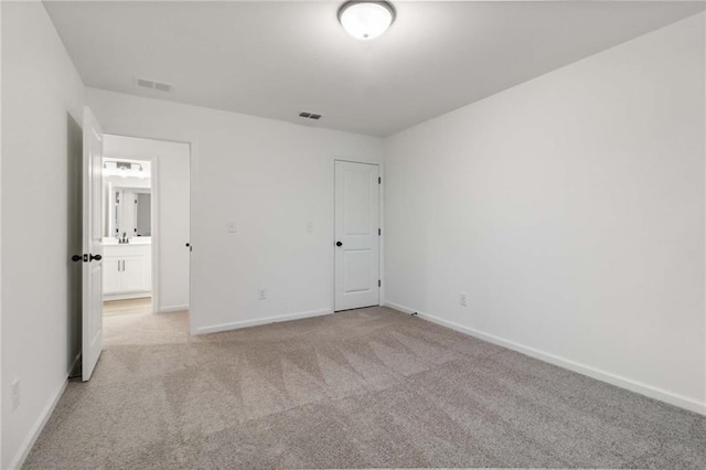 unfurnished bedroom with baseboards, visible vents, and light colored carpet