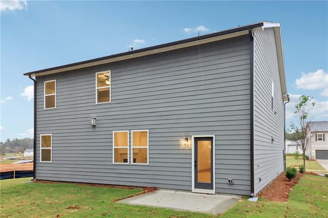 rear view of house with a yard and a patio