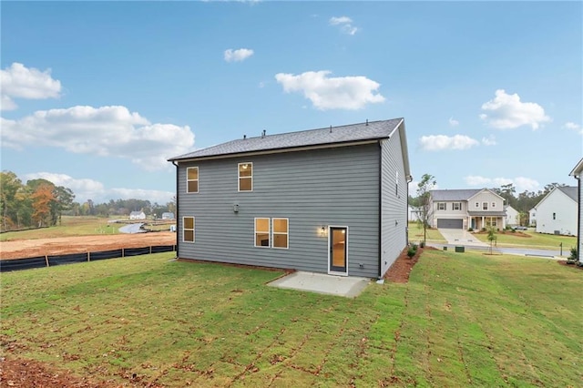 rear view of property featuring a patio area, fence, and a lawn