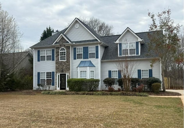 view of front of home with a front yard and fence