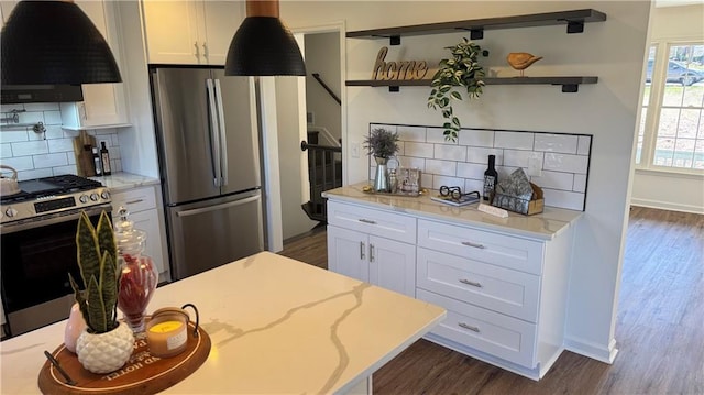 kitchen featuring dark wood finished floors, appliances with stainless steel finishes, exhaust hood, white cabinetry, and open shelves