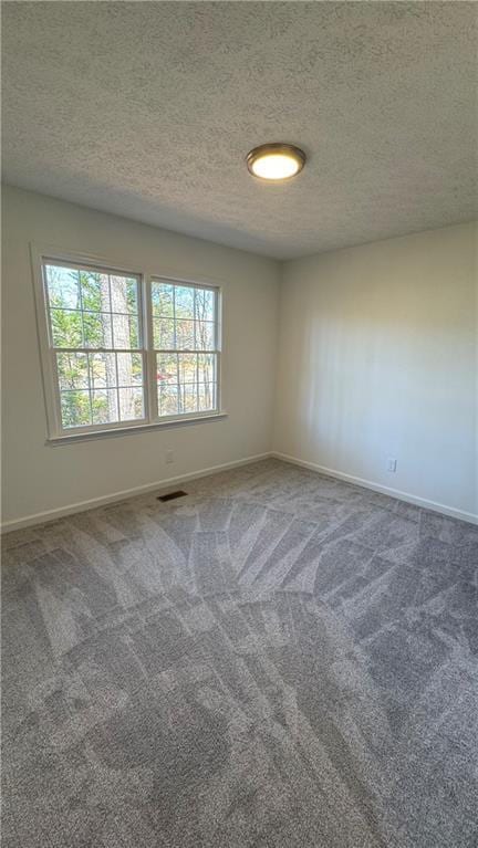 carpeted empty room with a wealth of natural light, visible vents, and baseboards