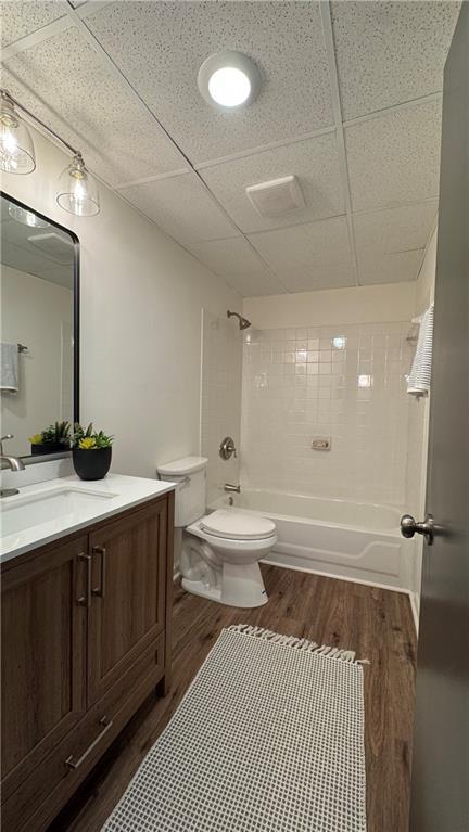 bathroom with vanity,  shower combination, toilet, and wood finished floors