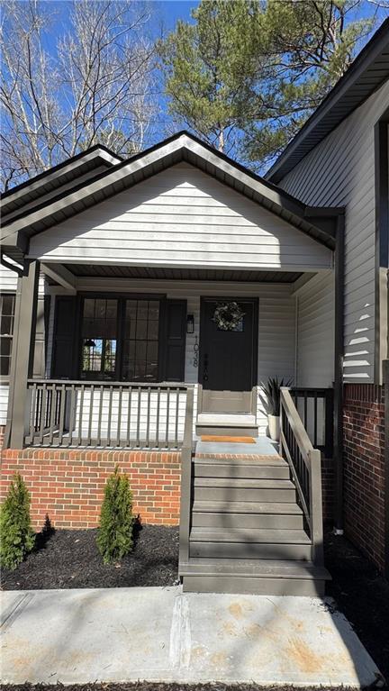 view of front facade featuring brick siding and a porch