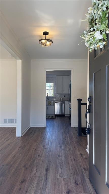 interior space featuring dark wood finished floors, crown molding, baseboards, and visible vents