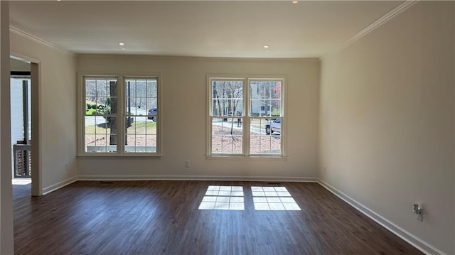 spare room with dark wood-type flooring, baseboards, and ornamental molding