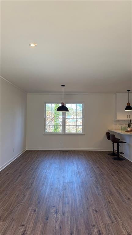 interior space featuring recessed lighting, baseboards, dark wood-style flooring, and crown molding