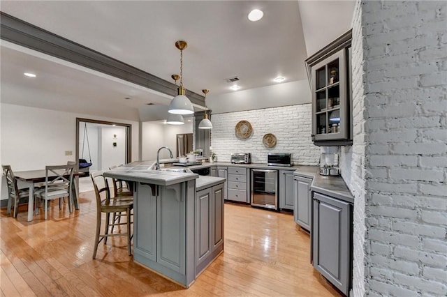 7920 Tintern Trce, Duluth, GA 30097 - kitchen featuring gray cabinetry, wine cooler, a breakfast bar, backsplash, and a peninsula