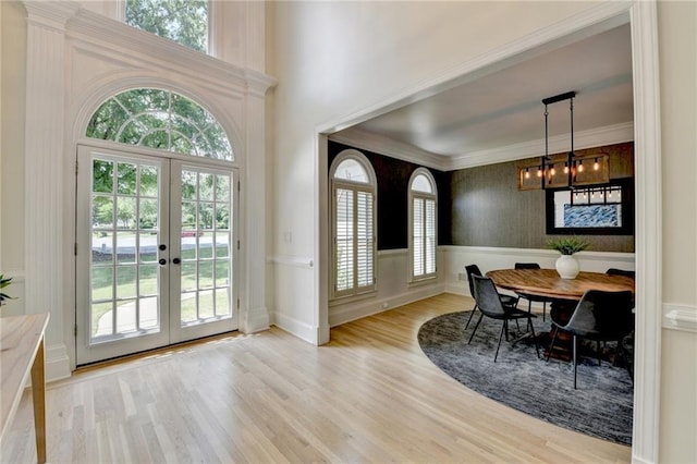7920 Tintern Trce, Duluth, GA 30097 - dining area with light wood finished floors, french doors, a chandelier, a wainscoted wall, and crown molding
