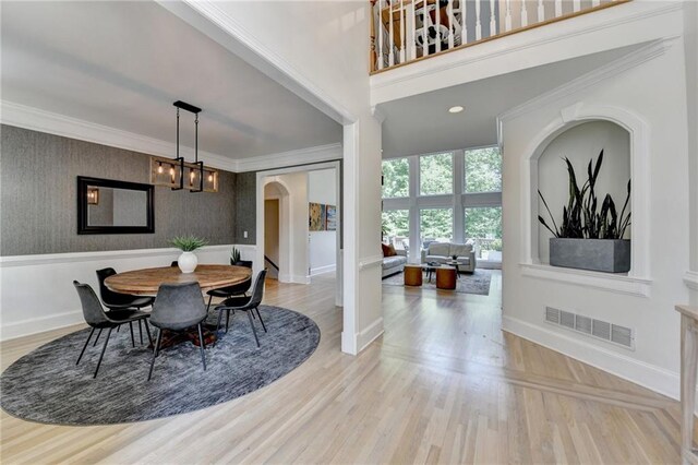 7920 Tintern Trce, Duluth, GA 30097 - dining room with arched walkways, baseboards, ornamental molding, wallpapered walls, and a chandelier