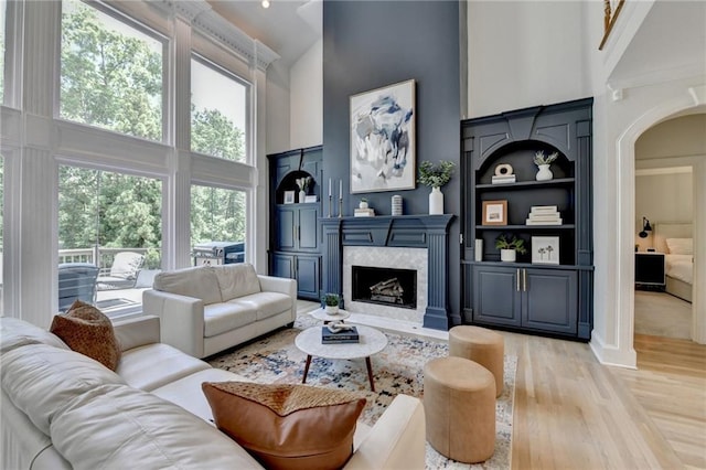 7920 Tintern Trce, Duluth, GA 30097 - living area with high vaulted ceiling, arched walkways, light wood finished floors, and a high end fireplace