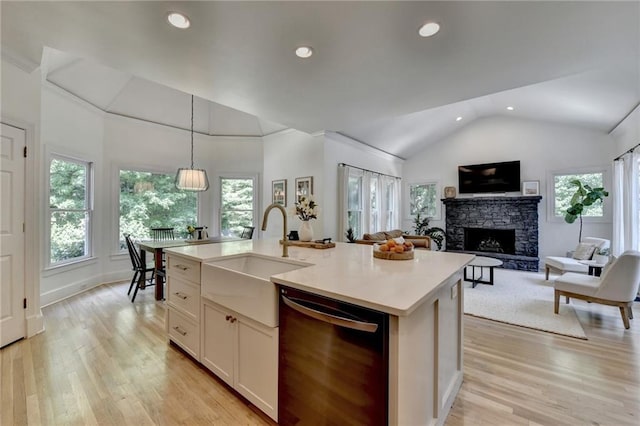 7920 Tintern Trce, Duluth, GA 30097 - kitchen featuring dishwashing machine, a sink, lofted ceiling, a stone fireplace, and light wood-type flooring
