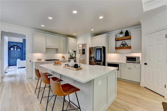 7920 Tintern Trce, Duluth, GA 30097 - kitchen featuring stainless steel fridge with ice dispenser, open shelves, ornamental molding, a kitchen breakfast bar, and light wood-style floors