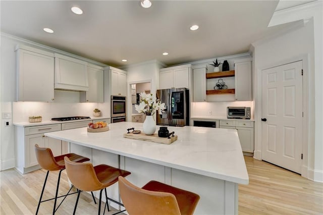 7920 Tintern Trce, Duluth, GA 30097 - kitchen with stainless steel appliances, open shelves, a breakfast bar area, light wood-style flooring, and ornamental molding