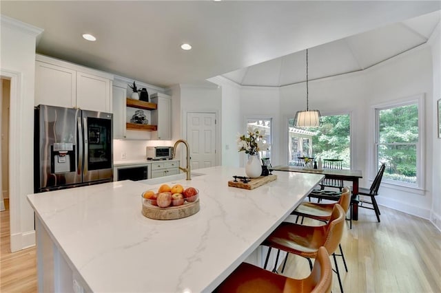 7920 Tintern Trce, Duluth, GA 30097 - kitchen featuring stainless steel fridge, open shelves, a sink, light wood-style flooring, and light stone countertops