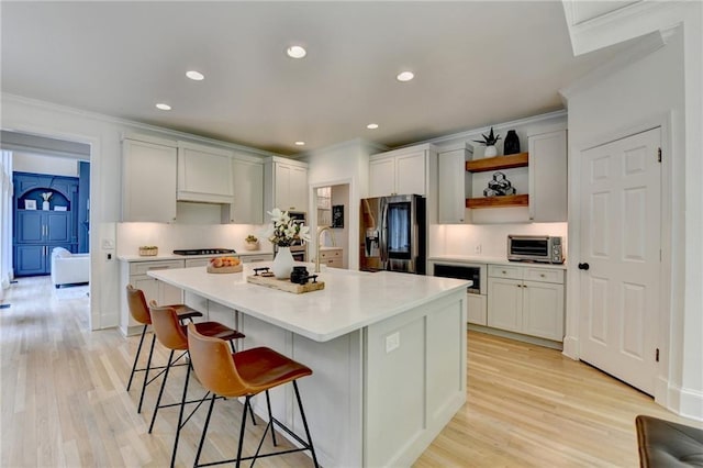 7920 Tintern Trce, Duluth, GA 30097 - kitchen featuring stainless steel fridge, ornamental molding, open shelves, a kitchen breakfast bar, and a kitchen island with sink