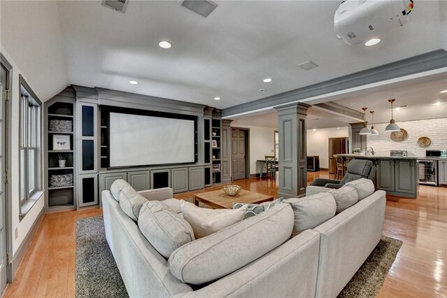 7920 Tintern Trce, Duluth, GA 30097 - home theater featuring ornate columns, wine cooler, light wood finished floors, recessed lighting, and vaulted ceiling
