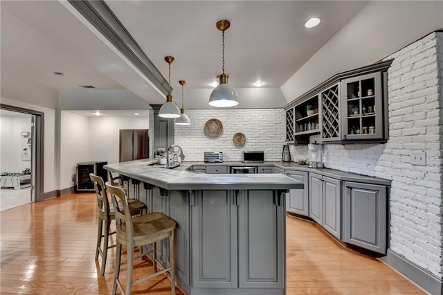 7920 Tintern Trce, Duluth, GA 30097 - kitchen with gray cabinetry, a kitchen breakfast bar, open shelves, and light wood-style flooring