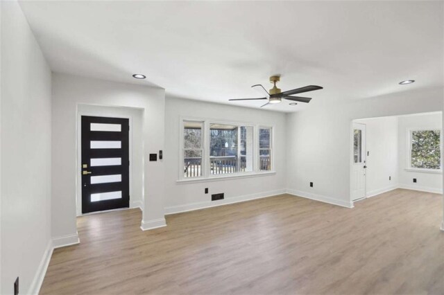 foyer with a ceiling fan, visible vents, light wood-style flooring, and baseboards