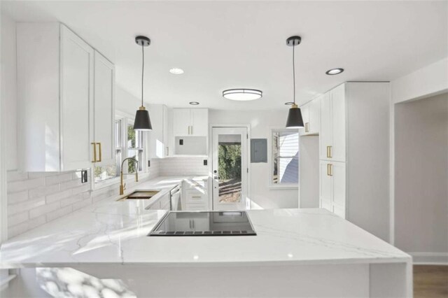 kitchen featuring pendant lighting, white cabinetry, a sink, a peninsula, and black electric cooktop