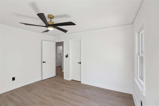 unfurnished room featuring ceiling fan, light wood-type flooring, and baseboards