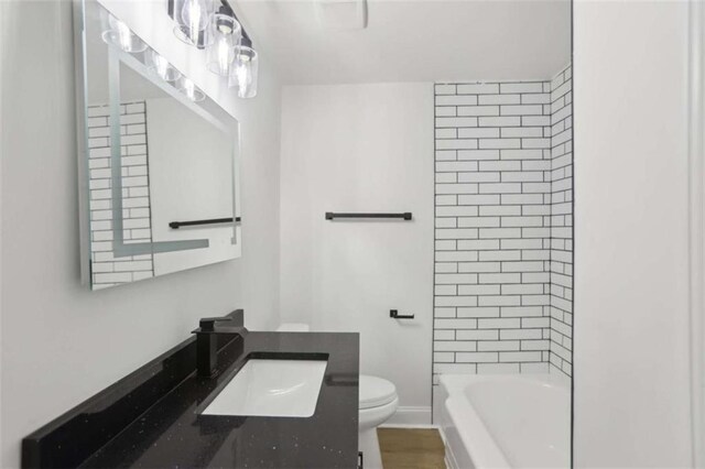 bathroom featuring shower / bathtub combination, vanity, toilet, and baseboards