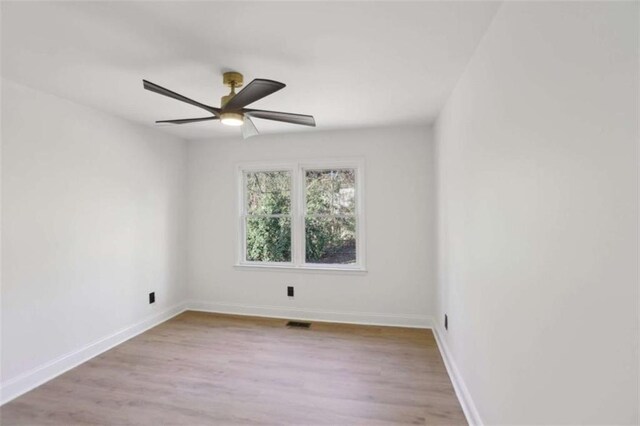 unfurnished room with light wood-style floors, visible vents, and baseboards