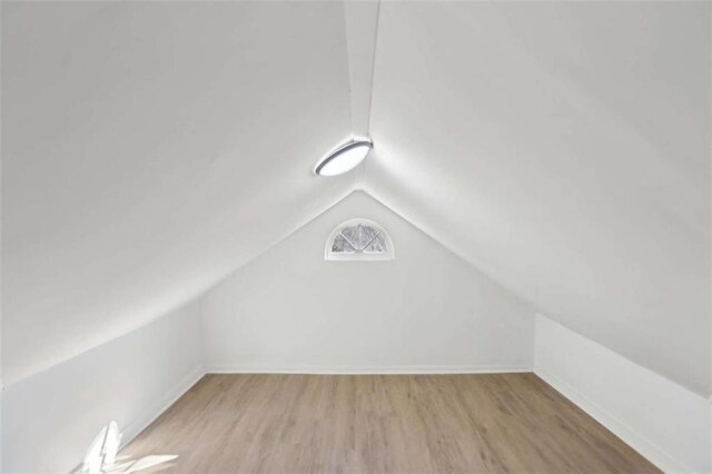 bonus room featuring vaulted ceiling and light wood-type flooring